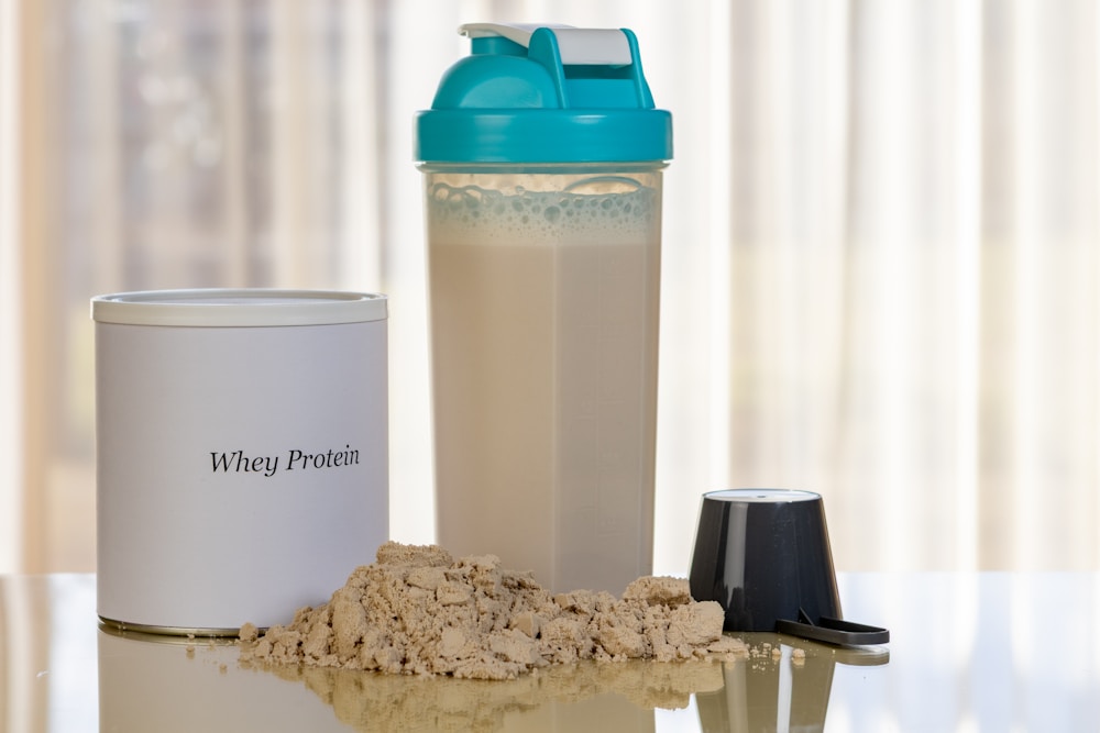 Creatine powder next to a shaker bottle, ready to mix