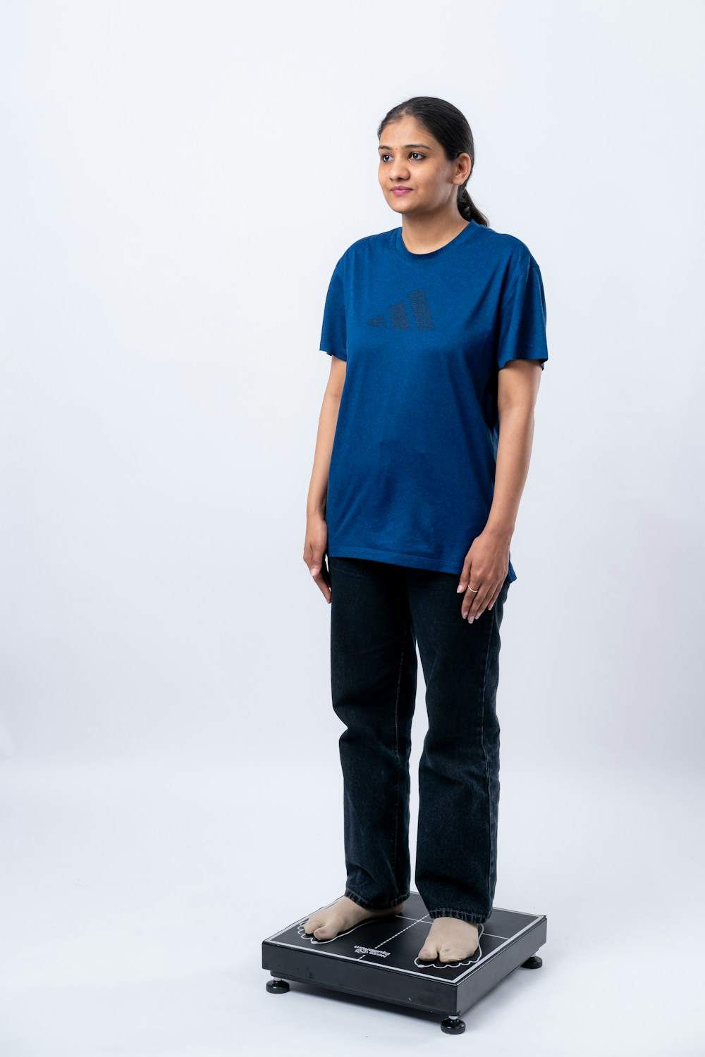 Person standing on a bioimpedance scale that estimates body fat percentage
