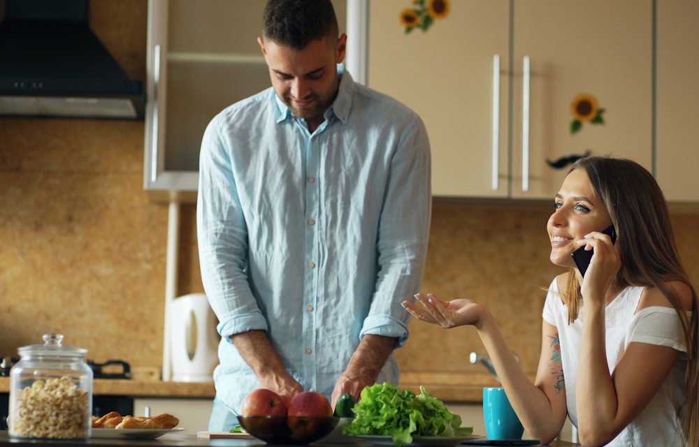 Couple using the diet app in the kitchen while preparing a meal