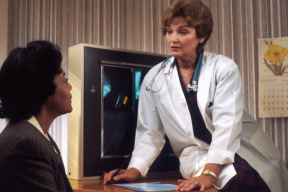 Médica conversa com paciente em consultório, quando o resultado da calculadora de IMC feminina pede avaliação