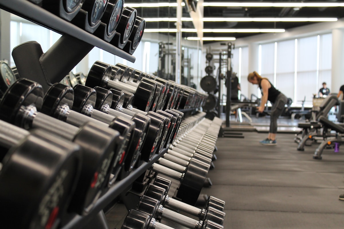 Athlete training with weights in a gym, applying progressive overload to build muscle