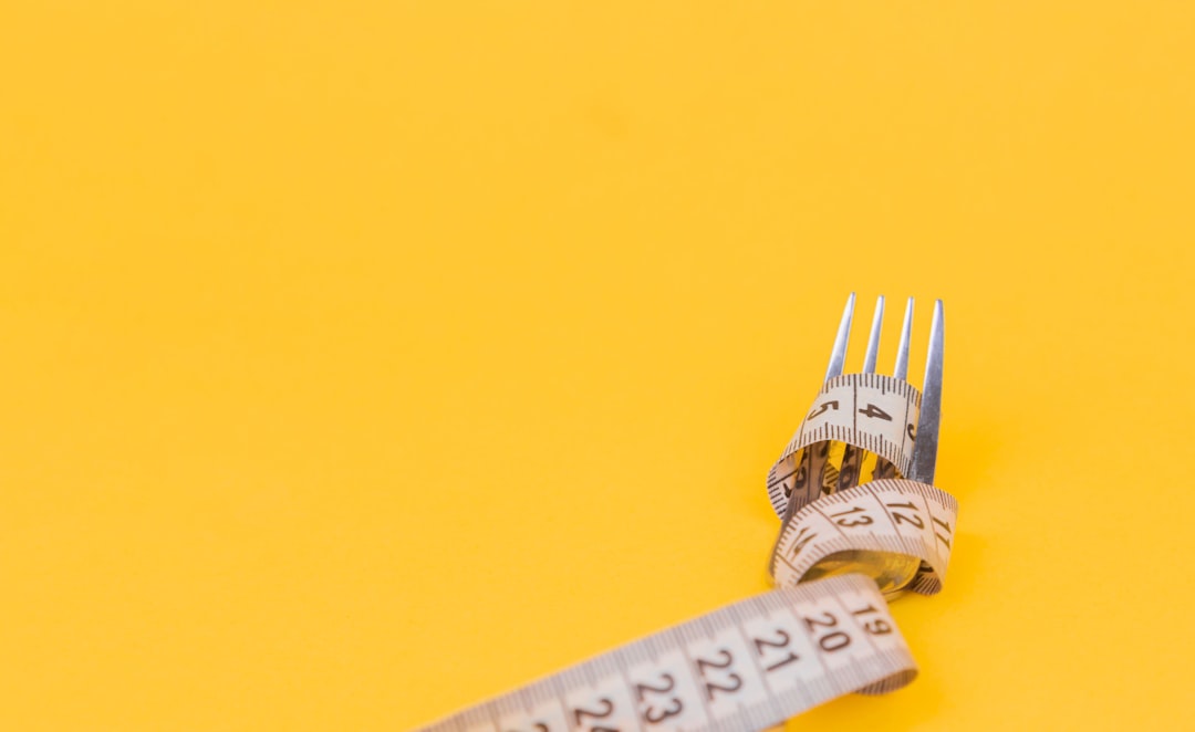 Measuring tape on a white table representing diet adjustment based on basal metabolic rate